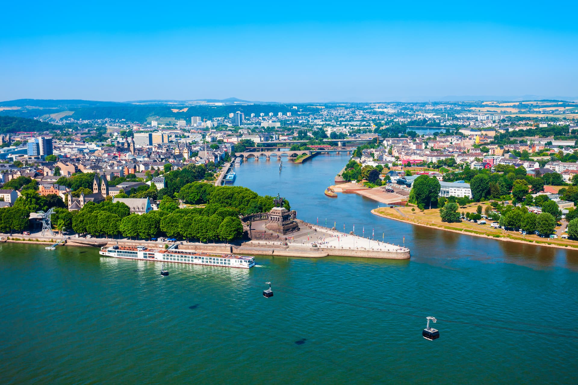 Koblenz panorama with Deutsches Eck monument, river confluence, cruise ship, and cable cars.