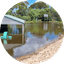 Flooded outdoor area with submerged basketball hoop and pavilion structure
