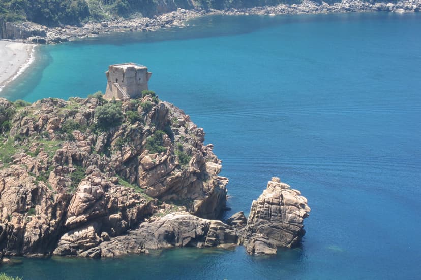 Porto Genoese tower on rocky coast overlooking blue sea in Corsica