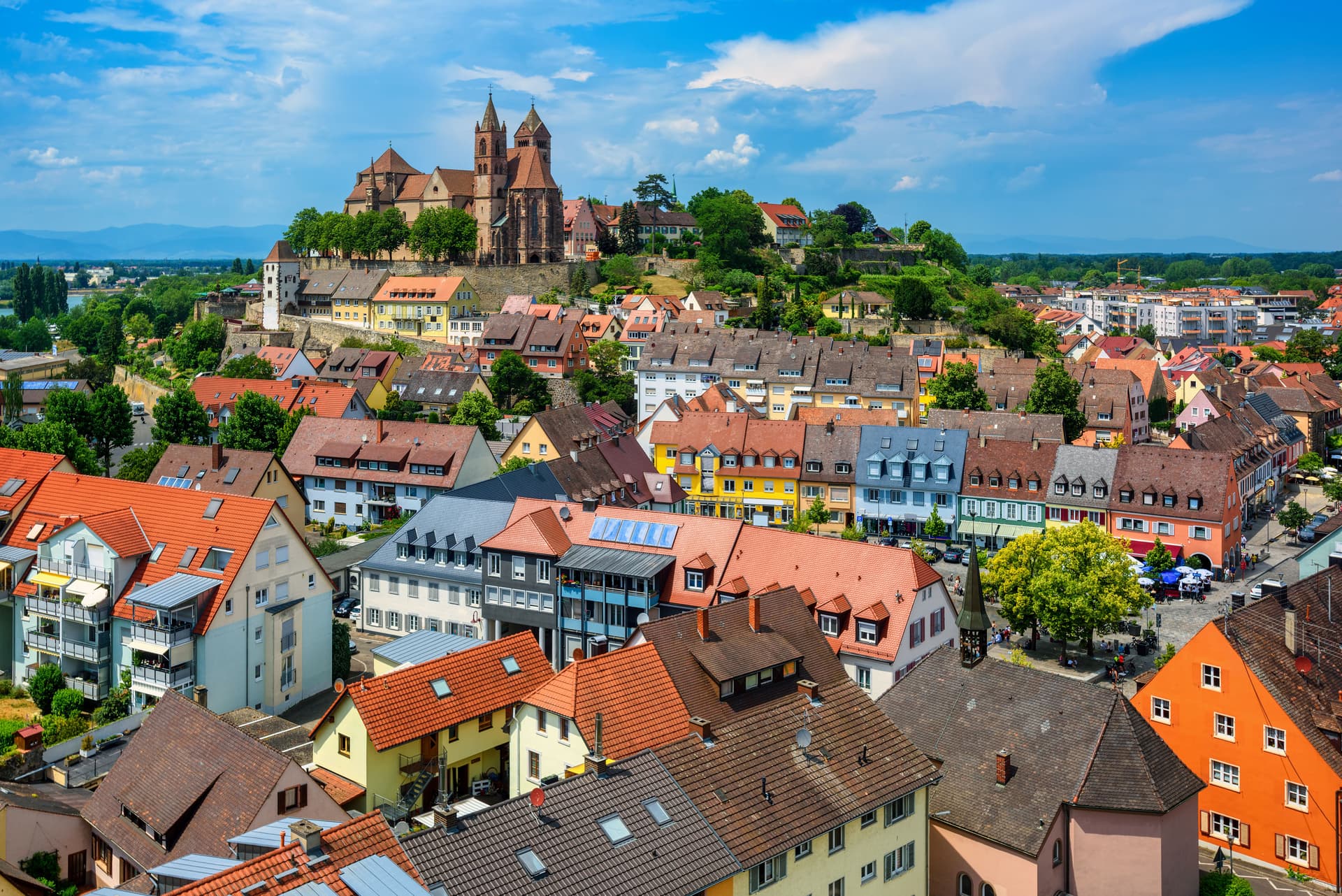Historic town of Breisach with colorful roofs and St. Stephen's Minster on hill.