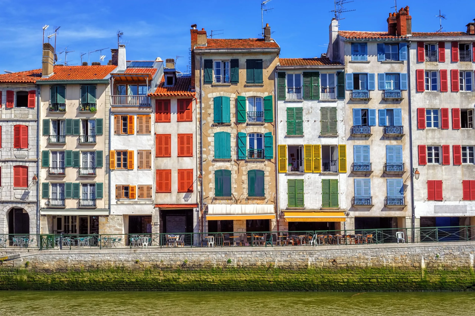 Traditional colorful facades along a canal waterfront in Bayonne, Basque Country, France