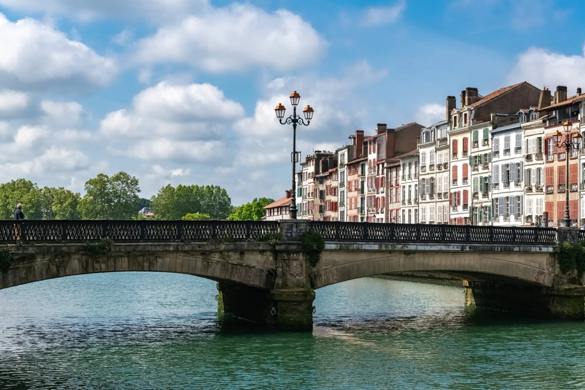 Stone bridge over the river Nive with colorful facades of Bayonne in the Pays Basque.