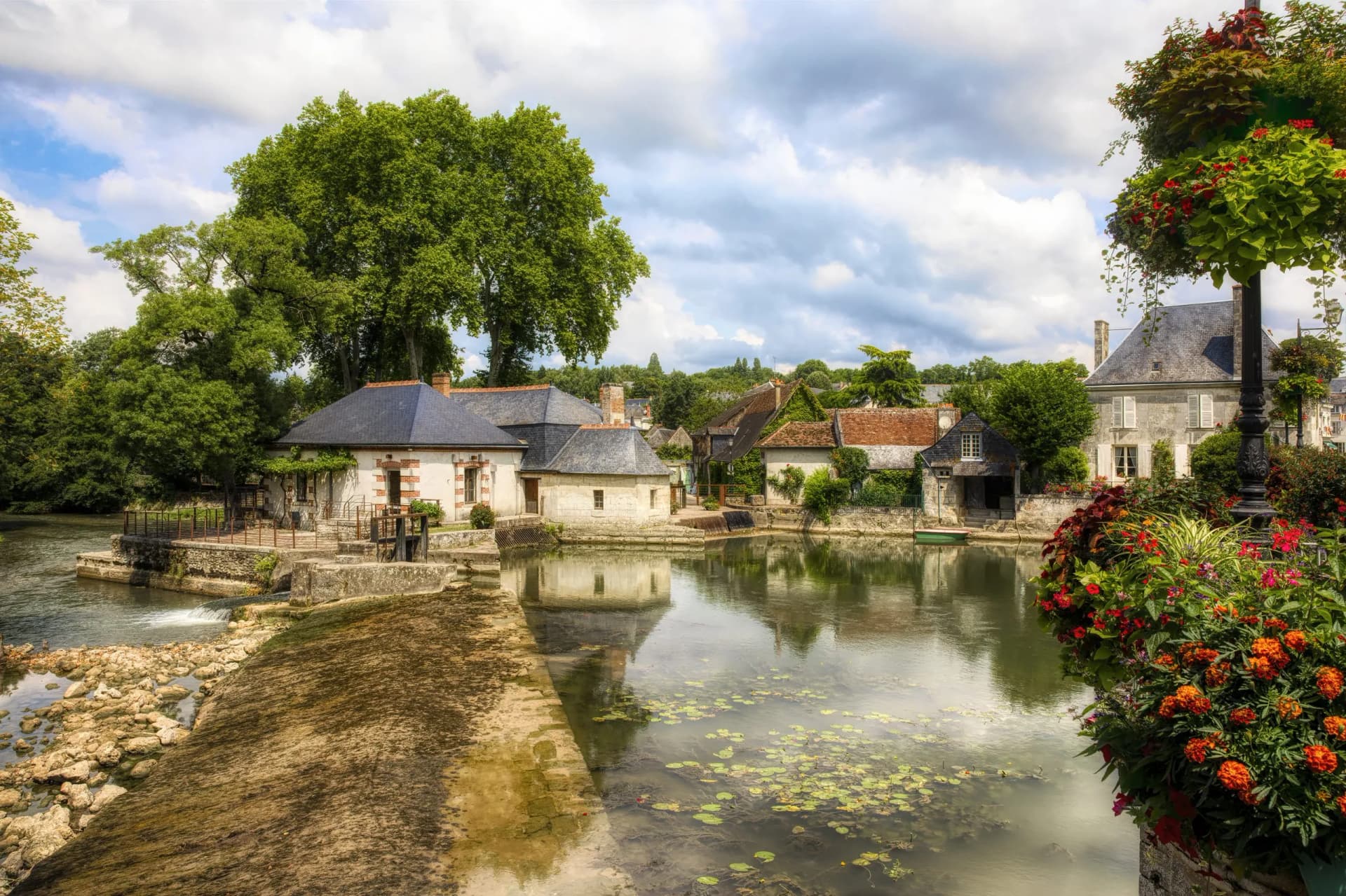 Old water mill and houses by the Indre River pond in Azay-le-Rideau, Loire Valley, France.