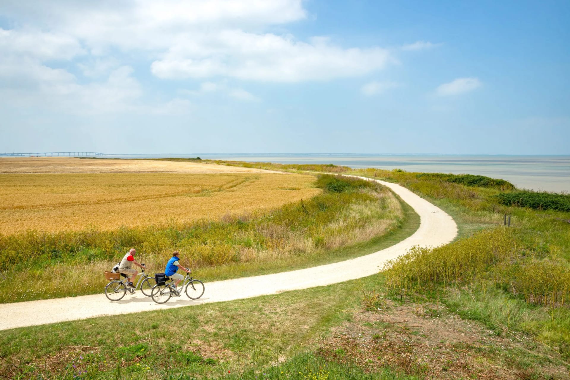 Senior couple cycling on coastal path near La Rochelle, Charente-Maritime, France.