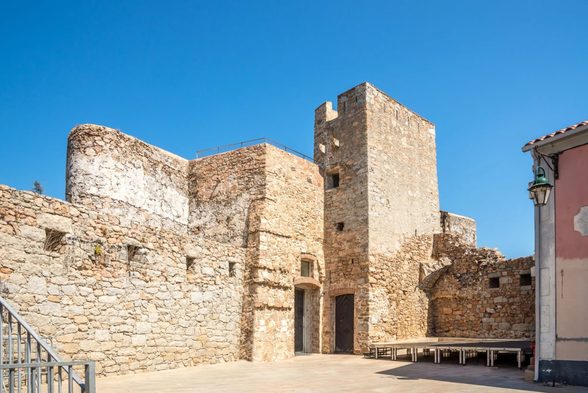 Stone walls of the old citadel courtyard under a clear blue sky in Porto Vecchio, Corsica.