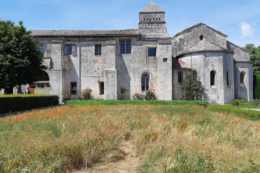 Saint-Paul-de-Mausole stone monastery with field of red poppies in foreground